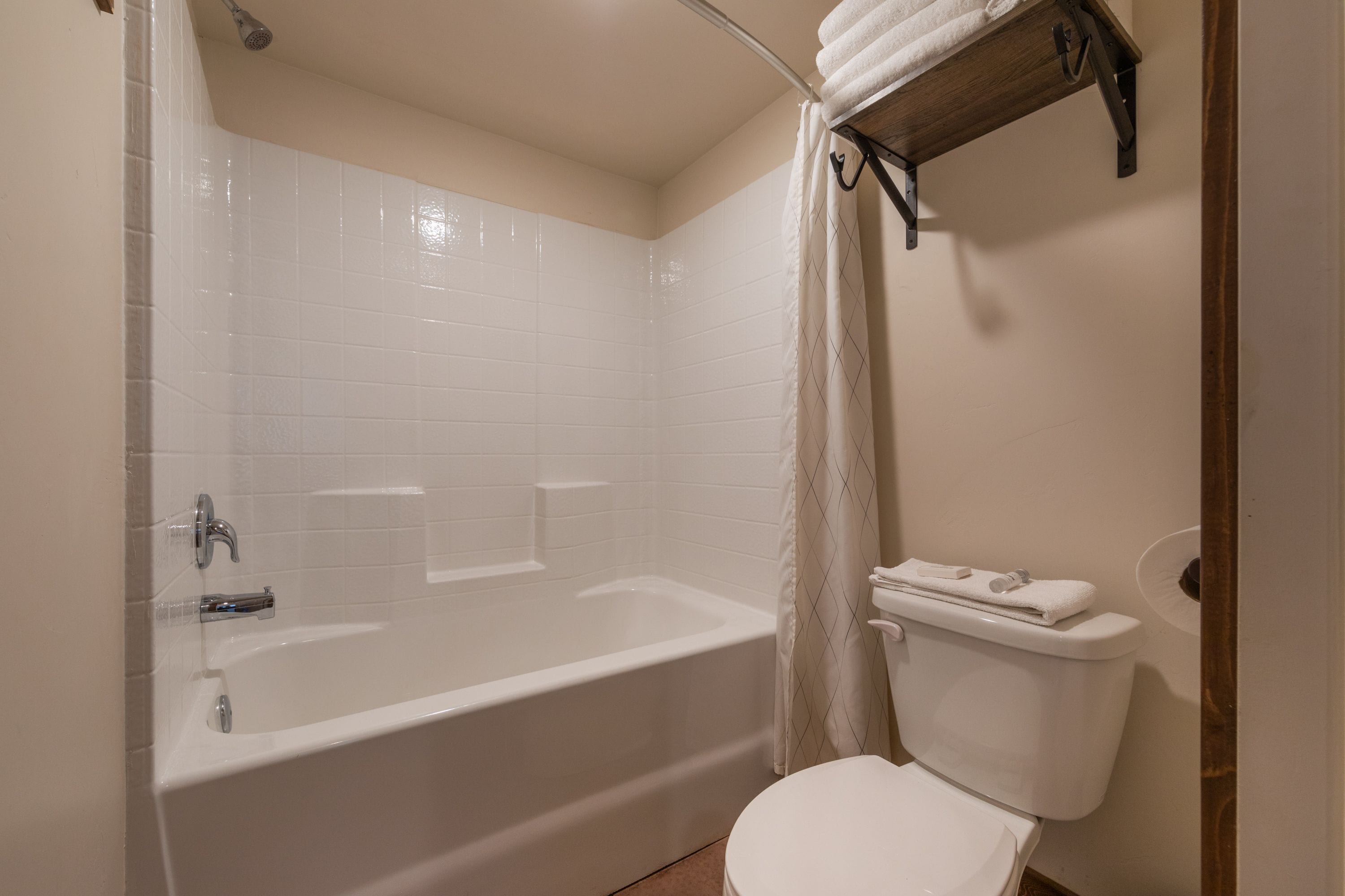 Un baño con una bañera blanca, un inodoro y una cortina de ducha.