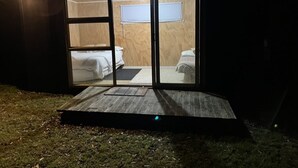 Una cabaña pequeña y cerrada con fachada de madera y un interior a un nivel.