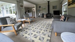 Una sala de estar moderna con sofás grises, un tapete estampado y una chimenea.