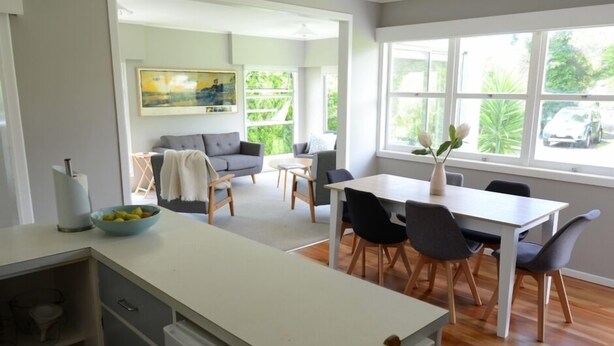 Una cocina moderna con comedor, ventanas amplias y vistas al exterior.