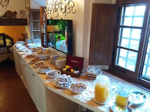 En buffet med forskellige retter og et fjernsyn, der viser et program.