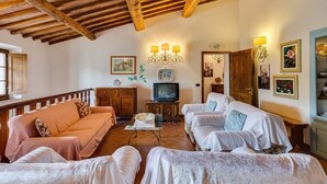 Una sala de estar acogedora con vigas de madera, televisor y chimenea.