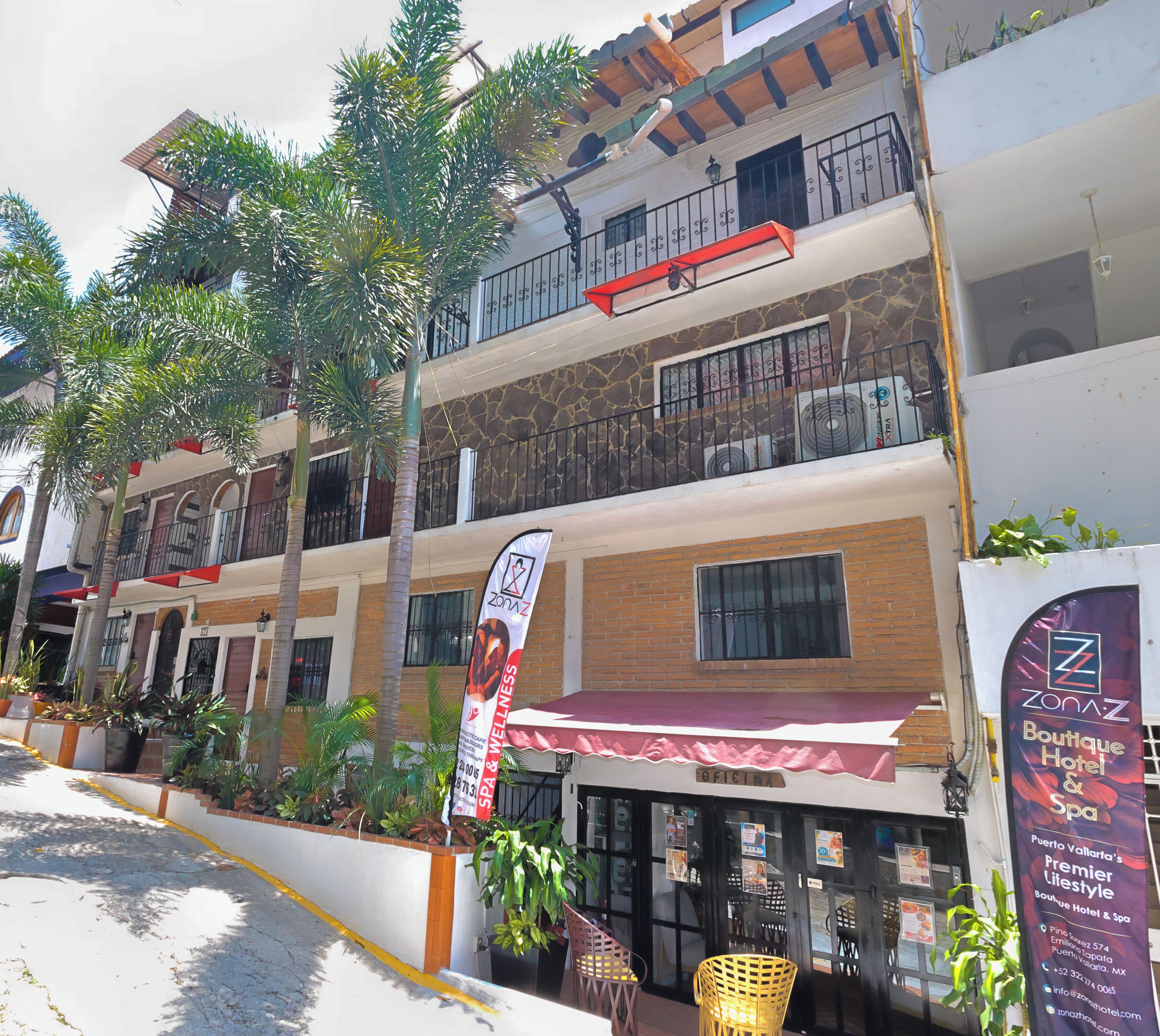 Un hotel de varios pisos con balcones, un spa y una sección estilo boutique.