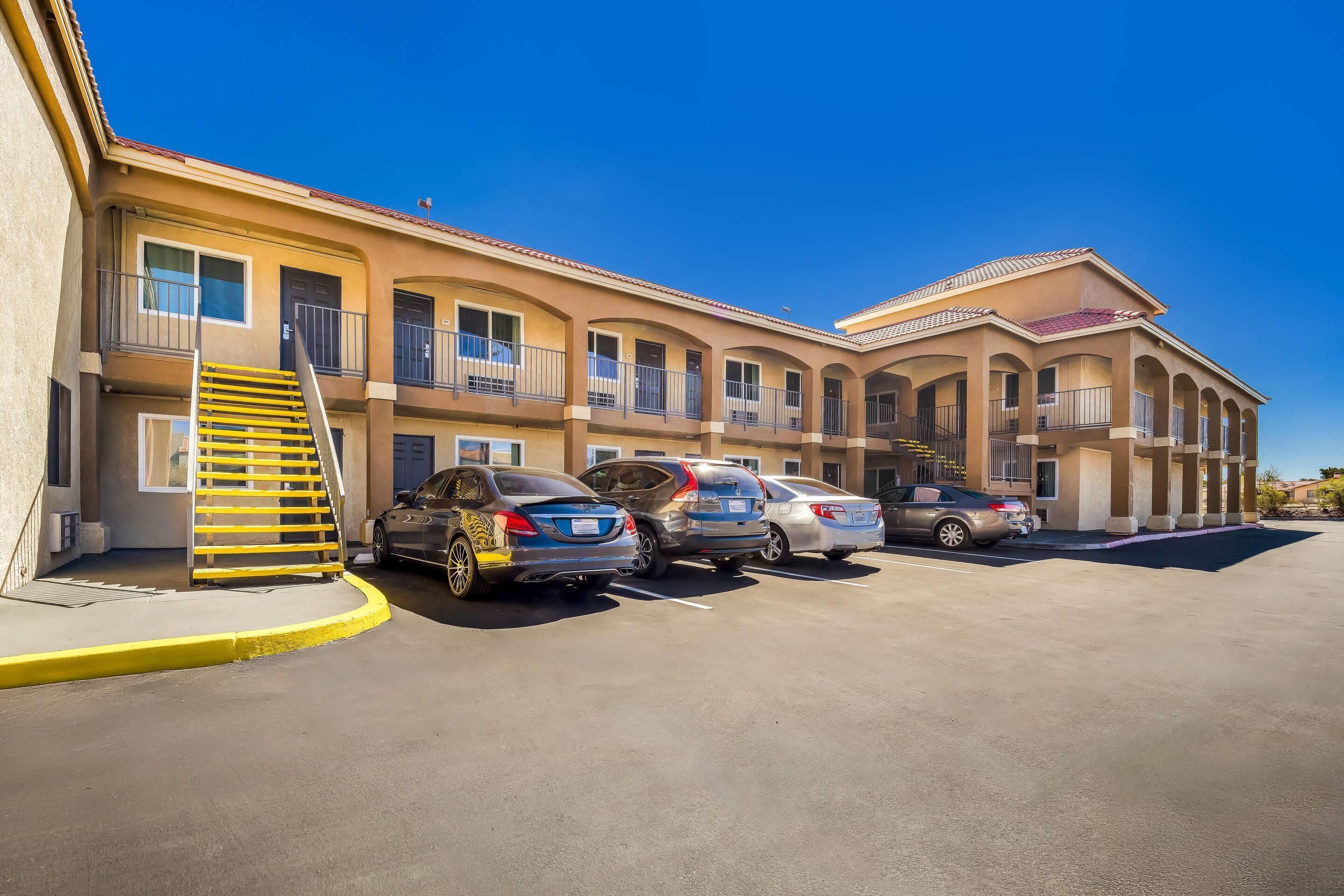 A multi-story hotel with a central courtyard, a covered parking area, and a staircase leading to the upper floors.