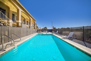 Una piscina al aire libre, sombrillas