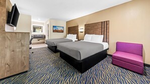A hotel room with two beds, a desk, a TV, and a view of the outdoors. - Quality Inn & Suites Victorville – Hesperia (Hesperia)