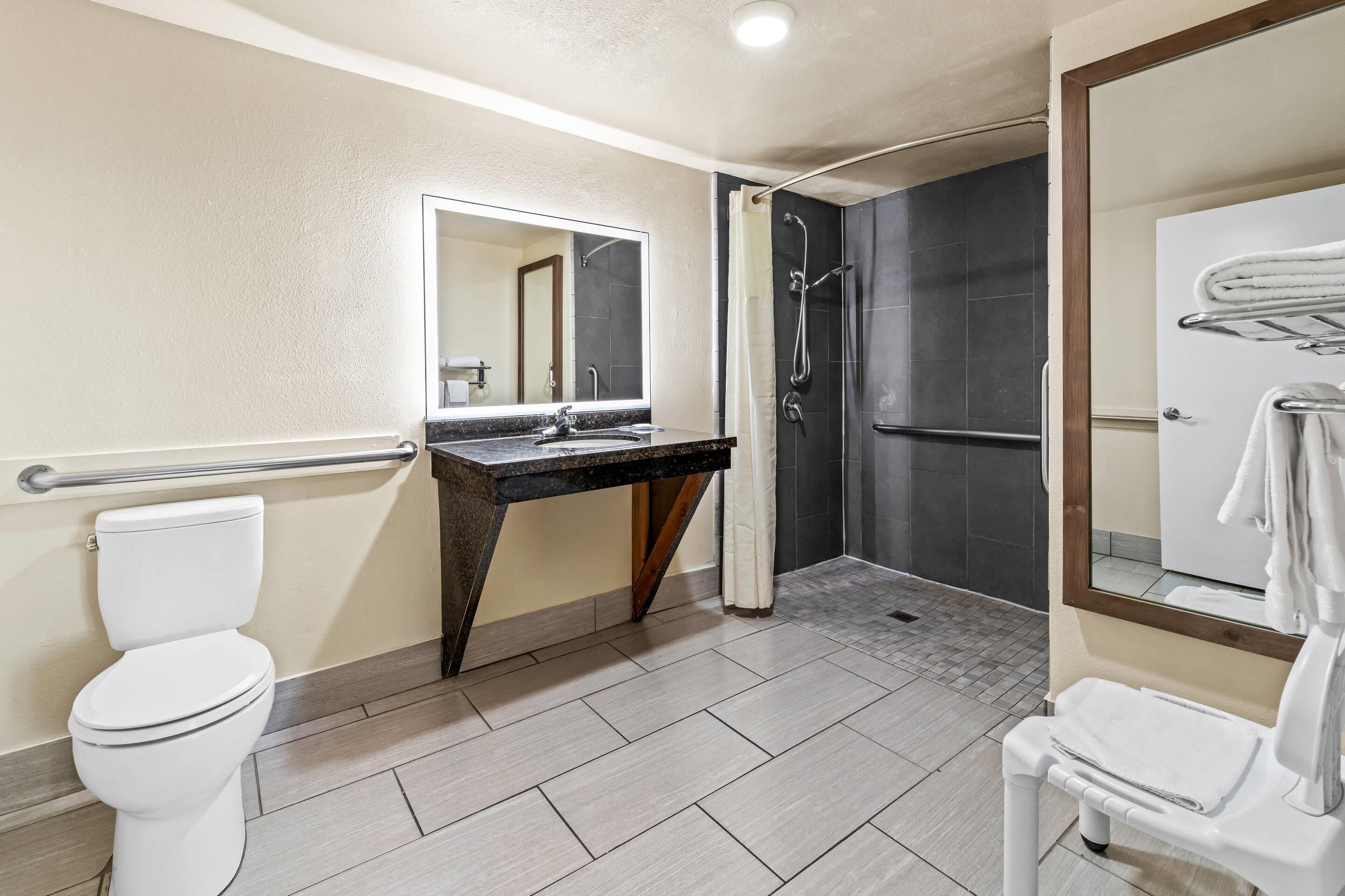 Un baño moderno con inodoro, lavamanos y ducha.