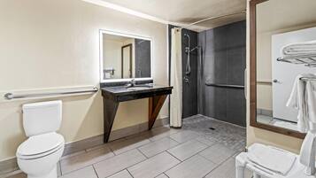 Un baño moderno con inodoro, lavamanos y ducha.