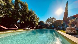 A clear swimming pool with lounge chairs and a decorative stone on the right side. - Large country house with swimming pool, SPA, terrace, garden, WIFI access 5 min from Sanary  (Ollioules)