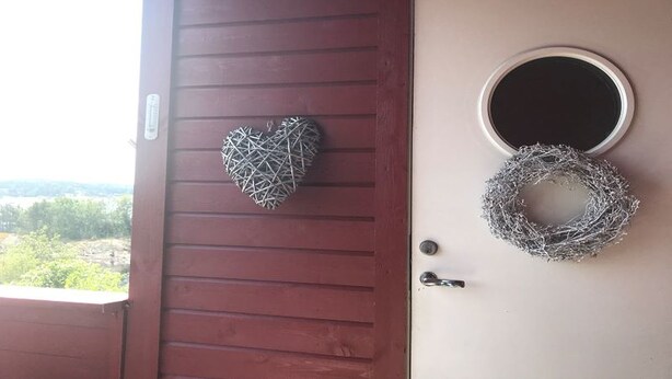 A wooden door with a heart-shaped decoration and a circular wreath. - Solferie Konsul Wilds vei 30b (Kristiansand)