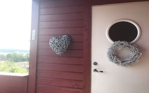 Une porte en bois ornée d’un motif en forme de cœur et d’une couronne circulaire.