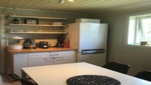 A compact kitchen with a refrigerator, a sink, and a countertop. There is a window providing natural light. - Solferie Konsul Wilds vei 30b (Kristiansand)