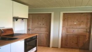 A compact kitchen with wooden cabinets, a built-in oven, and a sink. - Solferie Konsul Wilds vei 30b (Kristiansand)