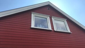 A red building with two white-framed windows and a triangular roof. - Solferie Konsul Wilds vei 30b (Kristiansand)