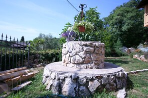 Surrounded by lush gardens, this serene outdoor space features a circular platform and a variety of plants.