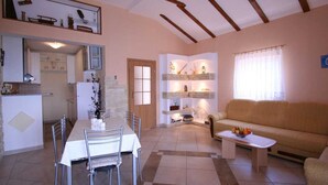 A compact living space with a dining area, kitchenette, and a sofa.