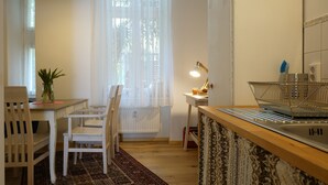 Eine Küche mit Holzarbeitsplatte, Spüle und einem Fenster mit durchsichtigen Vorhängen.