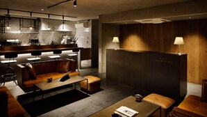 A modern lounge area with leather seating, a coffee table, and a fireplace. - Hotel Arcsens (Tokyo)