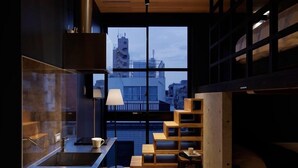 A modern interior with a kitchen, seating area, and a large window offering a city view. - Hotel Arcsens (Tokyo)
