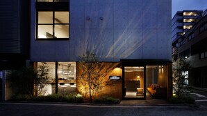 A modern hotel with a glass facade, a visible restaurant area, and a sign indicating a hotel. - Hotel Arcsens (Tokyo)