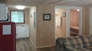 Un espacio habitable compacto con kitchenette, comedor y dormitorio.