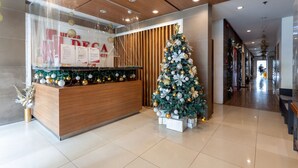 Ein Empfangsbereich mit einem Holztisch, einem Weihnachtsbaum und einer Wand mit einem Schild.