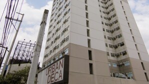 Ein hohes, modernes Gebäude mit mehreren Balkonen und einem Schild mit der Aufschrift "URBAN DECA".