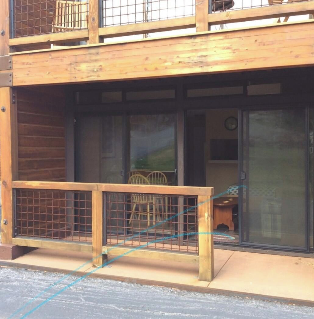 Ein Holzhaus mit Balkon und einem umzäunten Außenbereich.
