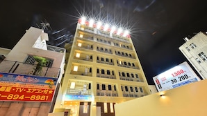 A multi-story hotel with balconies, a sign indicating room rates, and a contact number. - Chura Cabin Kokusai-Dori (Naha)