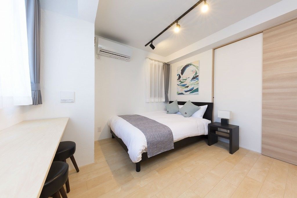 Une chambre moderne avec un lit, une table de chevet et un bureau avec des chaises.