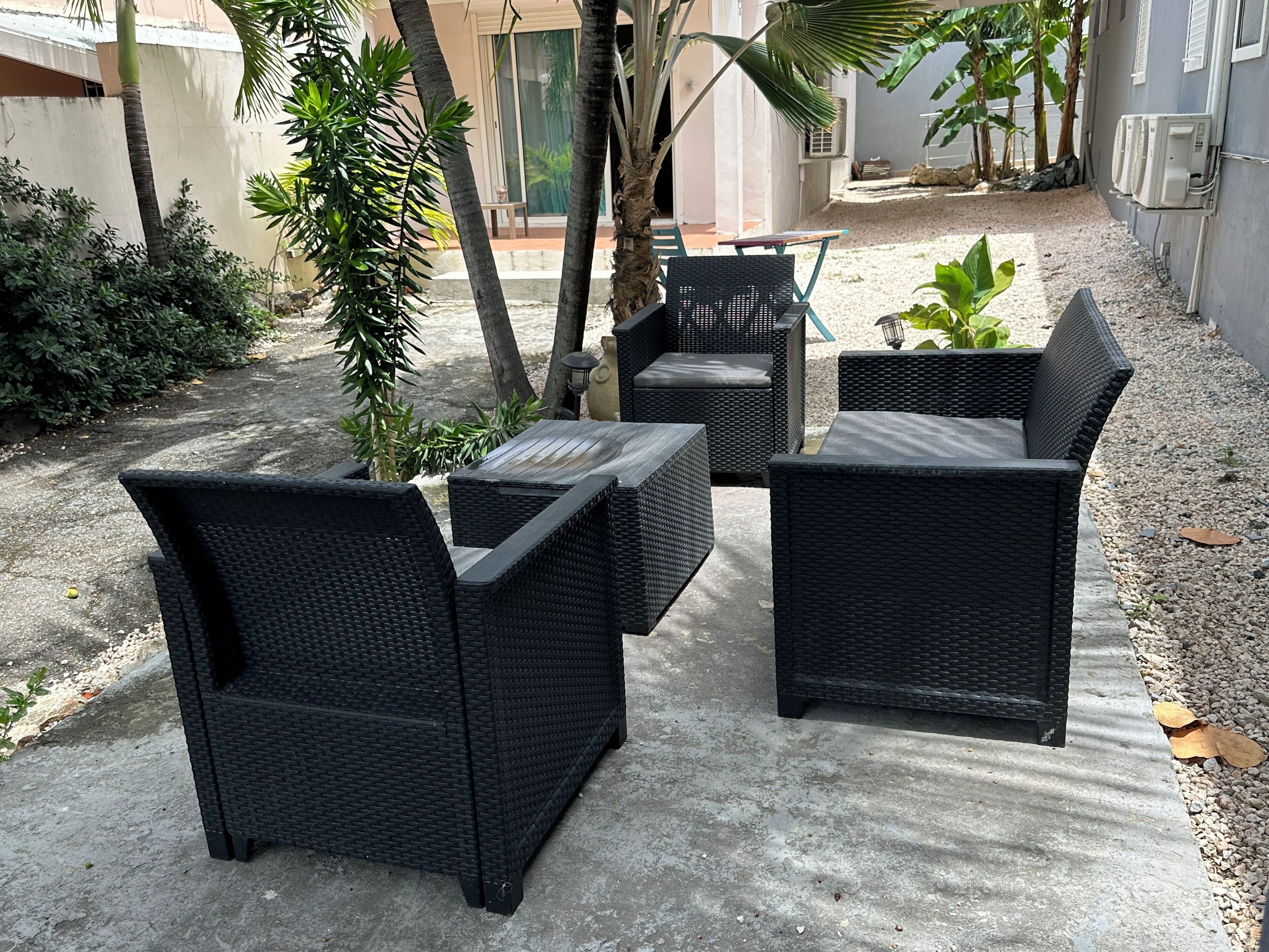A patio area with wicker furniture and a concrete floor.