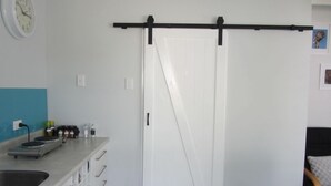 A kitchen with a sink, countertop, and a sliding door. - Fab Studio Plus!!- Pukekura Park/CBD right there (New Plymouth)