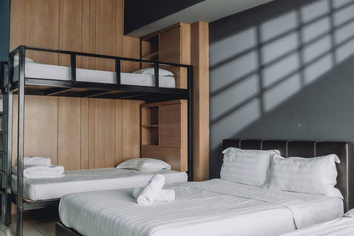 Ein Zimmer mit Etagenbett, Einzelbett und Kopfteil.