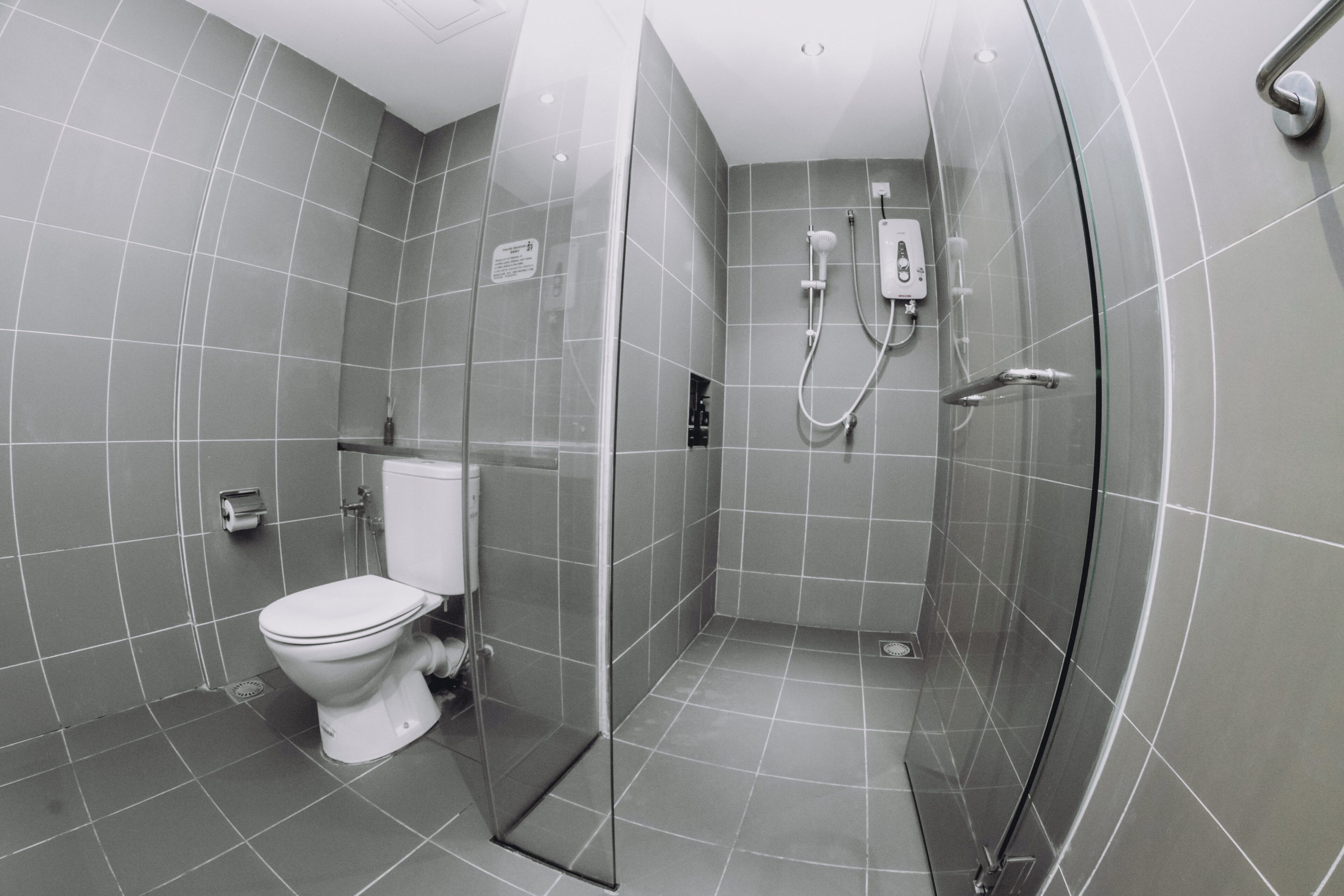 Un baño moderno con inodoro, ducha y cabina de ducha de vidrio.
