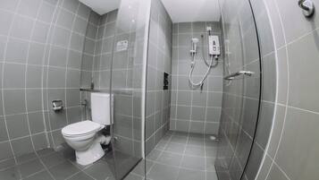 Un baño moderno con inodoro, ducha y cabina de ducha de vidrio.