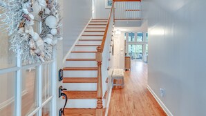 A staircase with wooden steps and a white railing, leading to an upper level.
