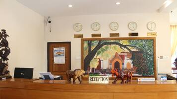 A reception desk with clocks displaying different cities, a painting of a tree, and a sign reading "RECEPTION".