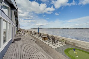 A wooden deck with outdoor seating and a view of the water. - Beachfront Whidbey Island Home + Apartment! (Langley)