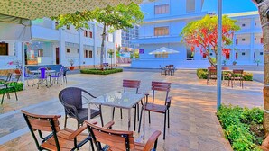 A courtyard with outdoor seating, a fountain, and a building with multiple floors. - Bo Xay Dung Vung Tau (Ho Chi Minh City)