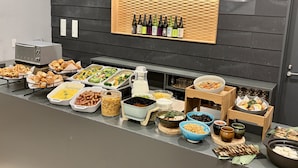 Una mesa de buffet con diversos alimentos y bebidas.