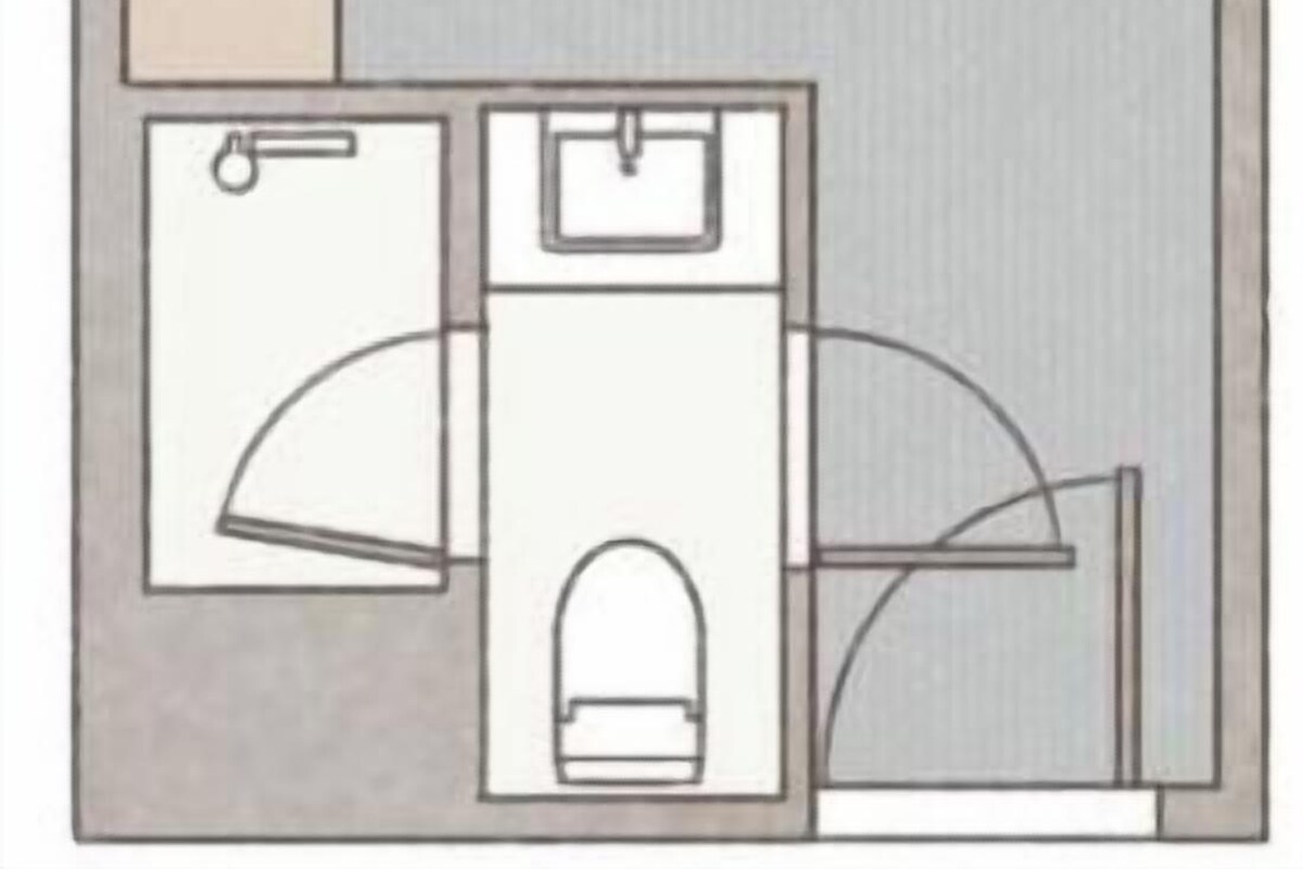 A hotel room layout with a bed, a bathroom, and a small sitting area.