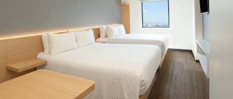 A modern hotel room with two beds, a wooden nightstand, a flat-screen TV, and a window with a city view.
