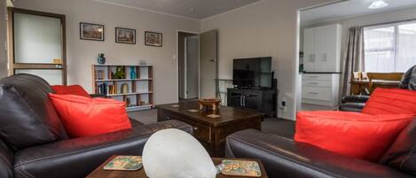 A living room with a sofa, a coffee table, and a decorative pig statue.
