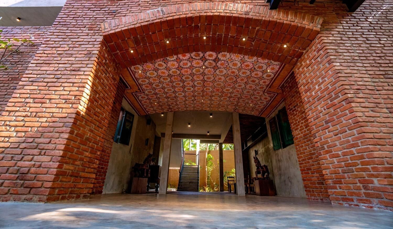 An entrance with a brick archway and a patterned ceiling.