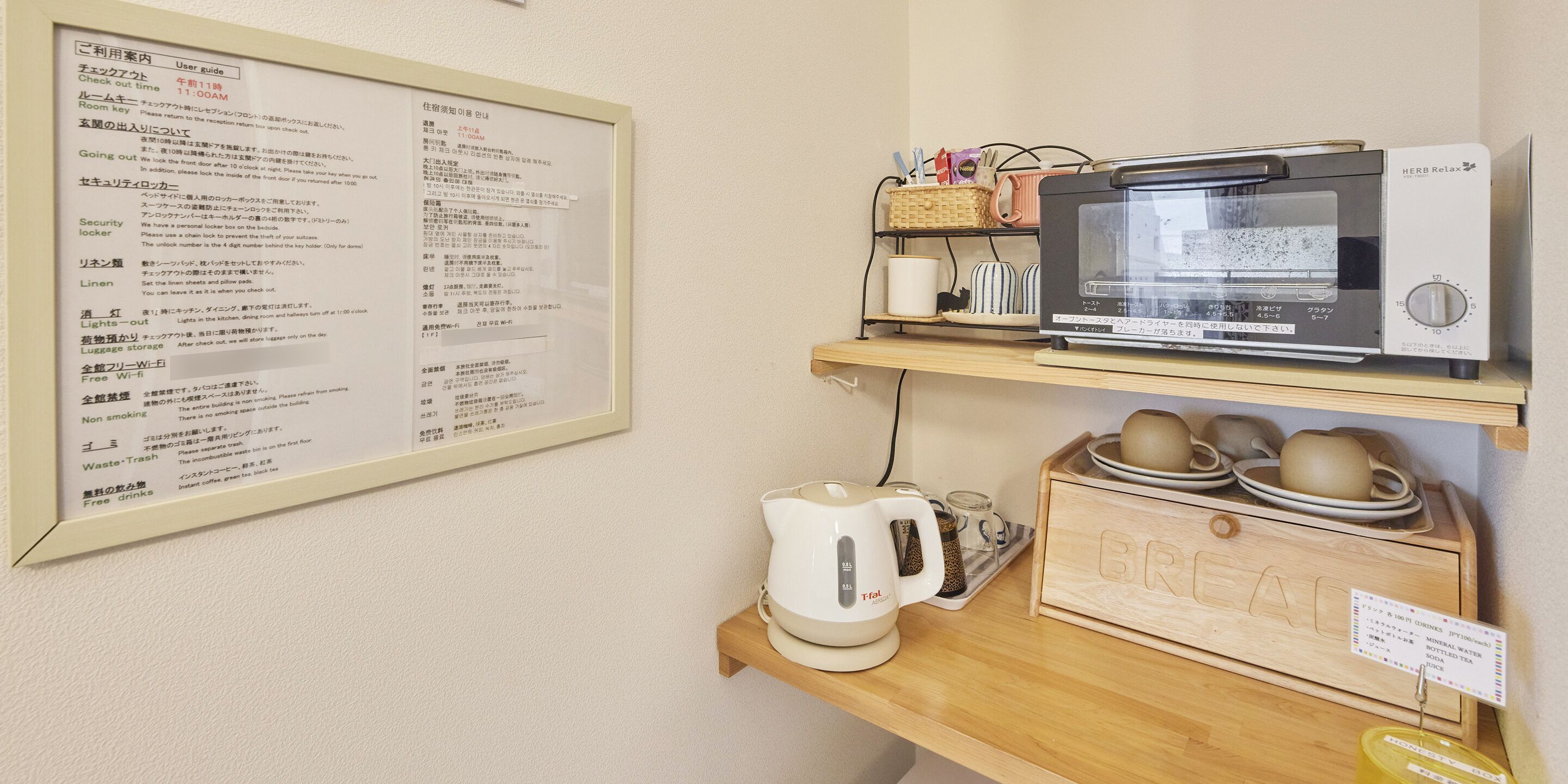 A kitchen area with a microwave, kettle, and a coffee maker on a wooden shelf.