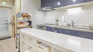 Una cocina moderna con cubierta blanca, una cafetera y un microondas.