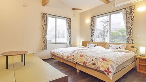 Un dormitorio con cama, una mesita y una mesita de noche con lámpara.
