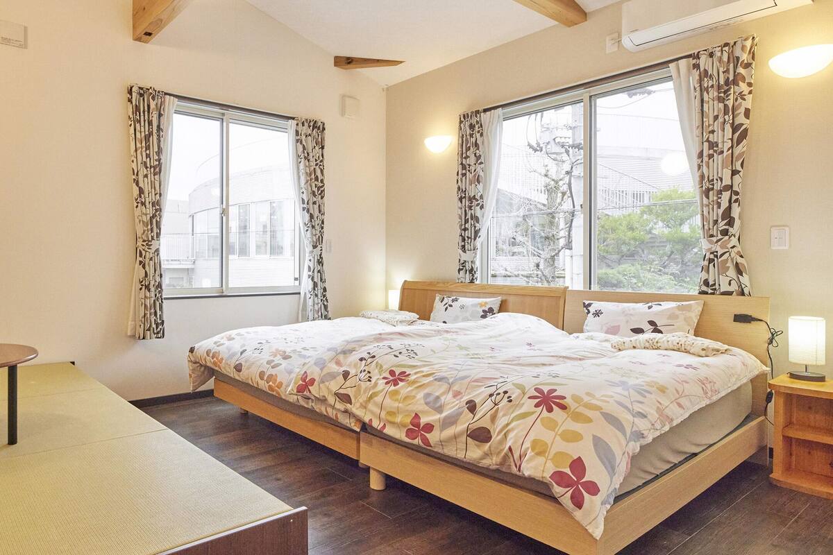 Een slaapkamer met een bed, een klein tafeltje en een nachtkastje met een lamp.