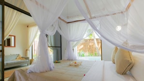 Un dormitorio con cama, sofá y ventana con cortinas.