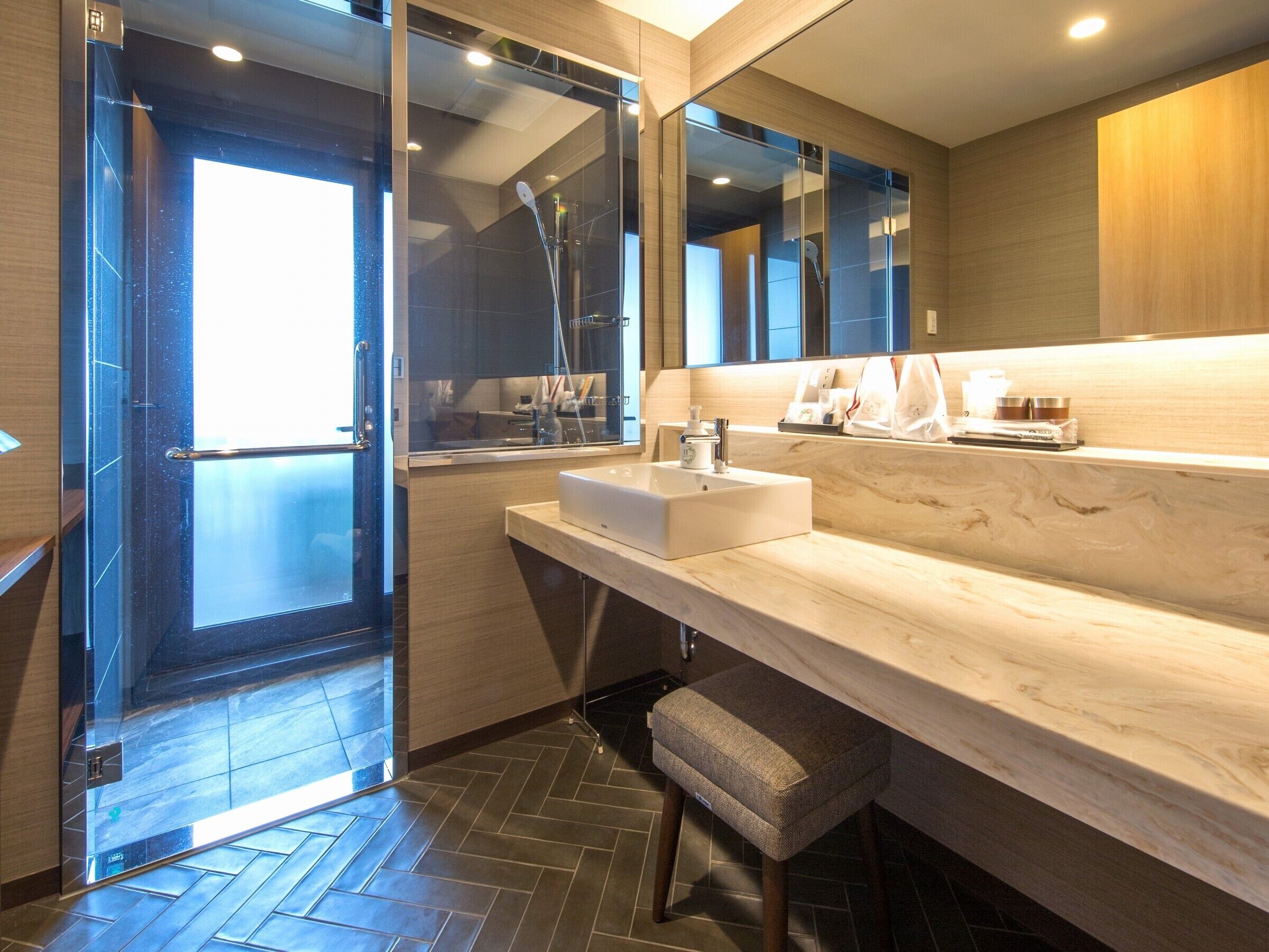 Une salle de bain moderne avec une douche à parois de verre, un lavabo et un meuble-lavabo.